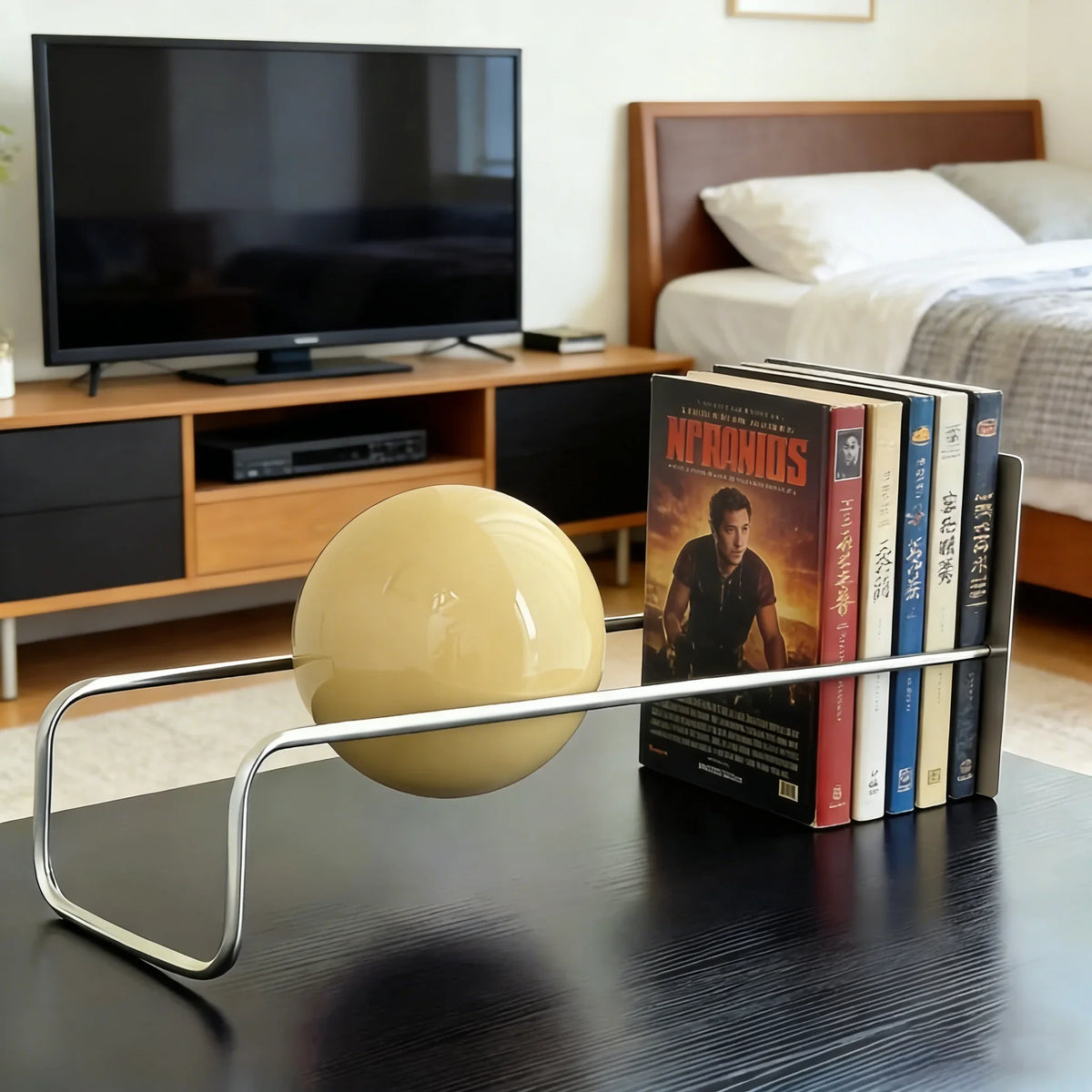 Sculptural Metal Desktop Organiser with a cream sphere near a TV