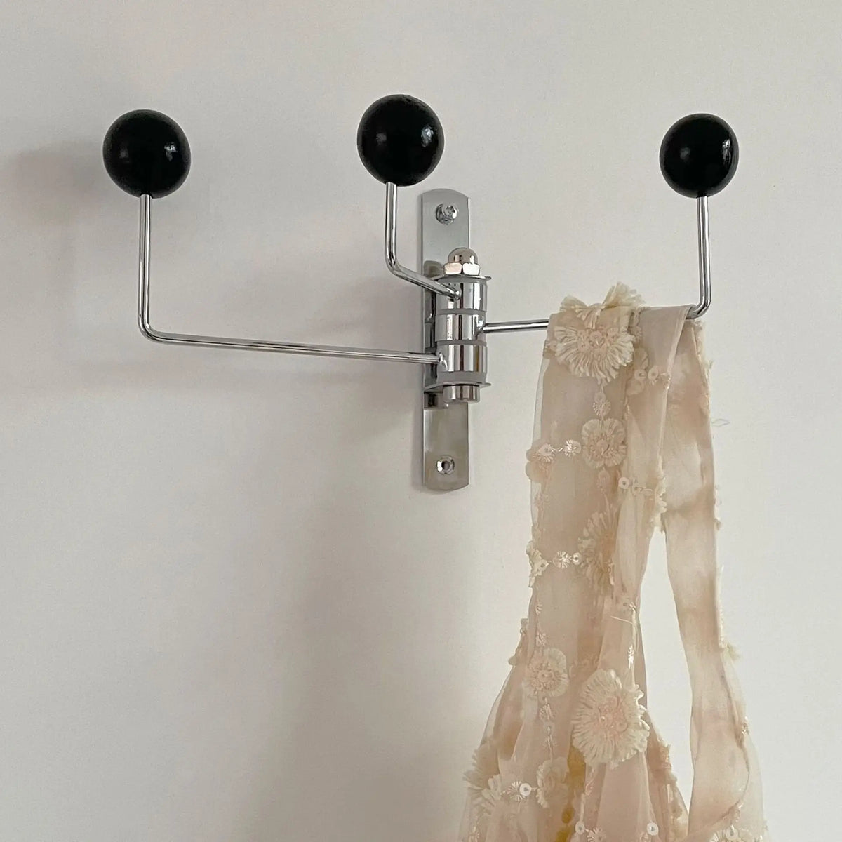 Vintage rotating iron coat hook with lace on a wall