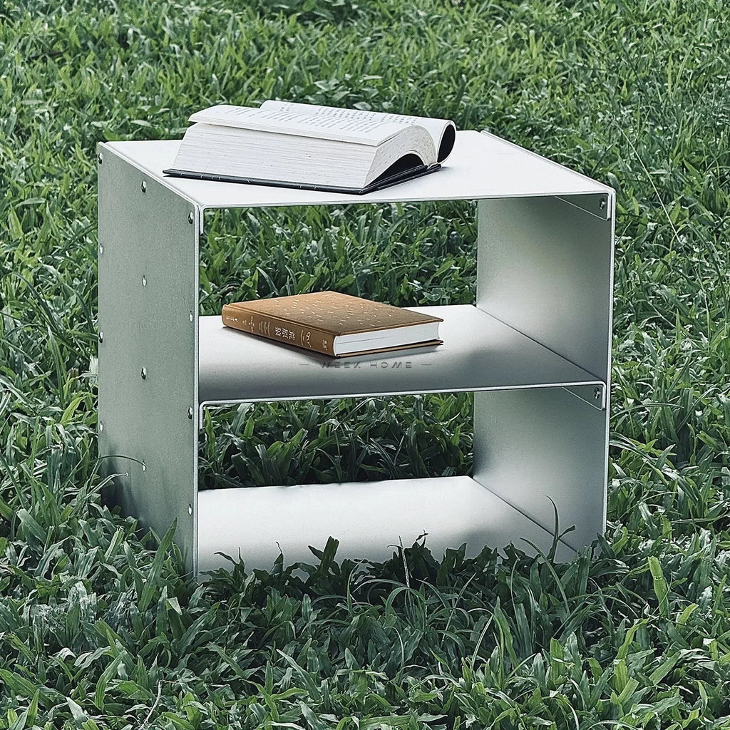 Bauhaus Modular Stainless Steel Shelf on a green lawn with a book